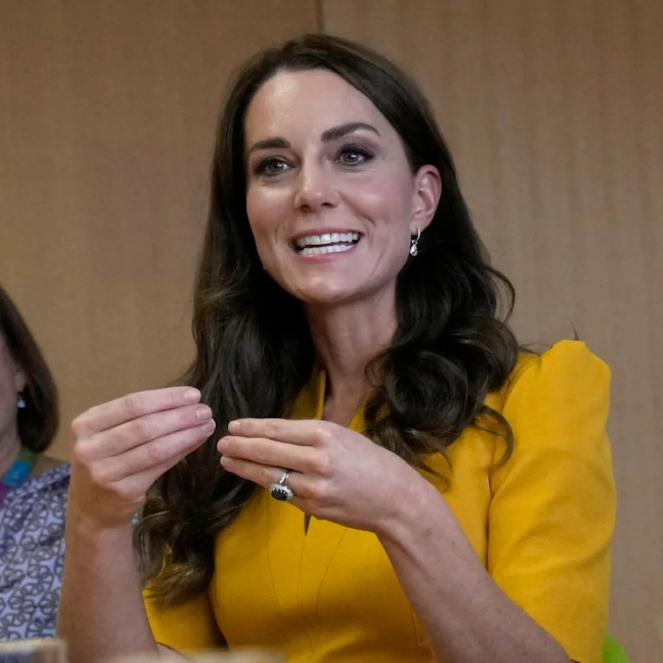  Kate Middleton wears a yellow dress to visit the Royal Surrey County Hospital's Maternity Unit on October 5, 2022. 