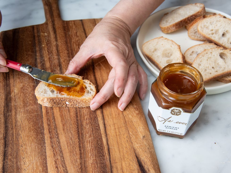 meghan markle as ever apricot spread being slathered on a slice of baguette