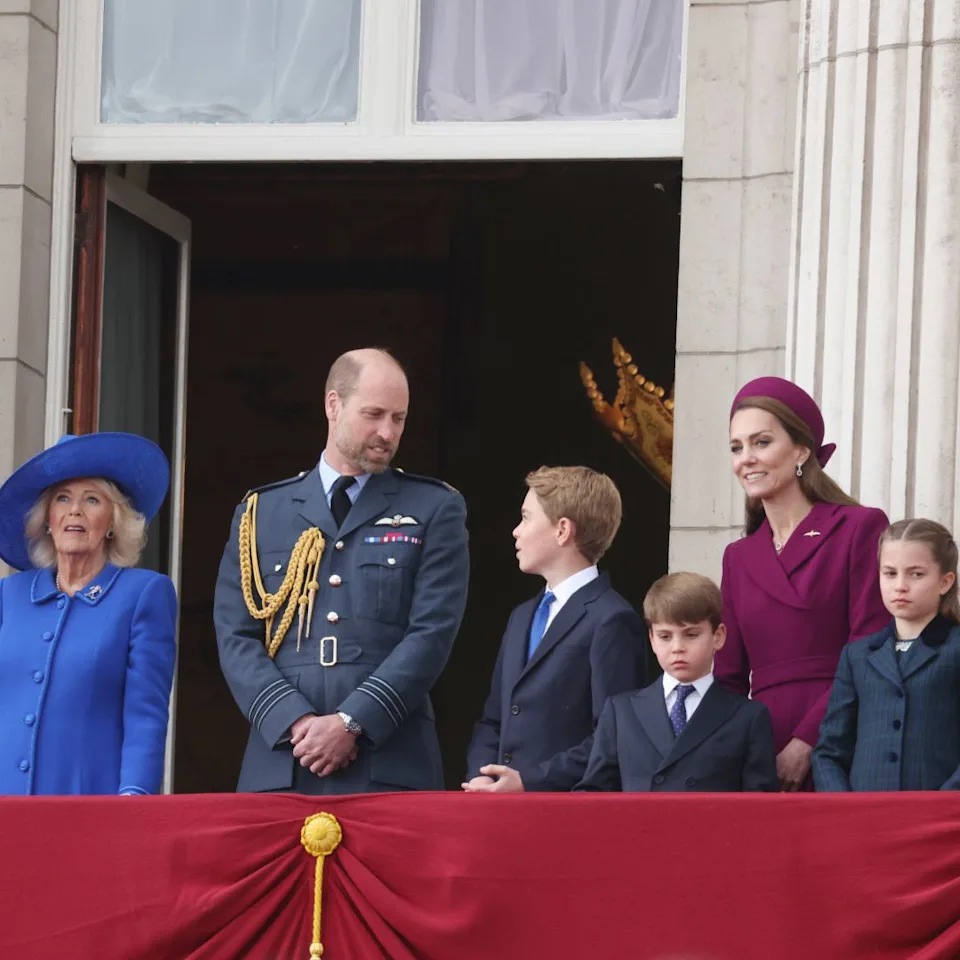 Queen Camilla, Prince William, Princess Kate, Prince George, Prince Louis and Princess Charlotte standing on the balcony of Buckingham Palace.