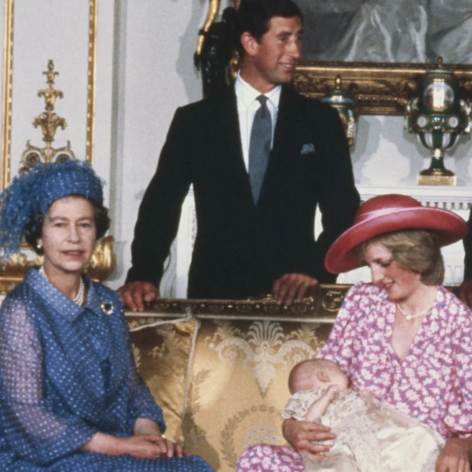  Princess Diana wears a pink floral dress and pink hat to hold Prince William on August 4, 1982 at his royal christening. 