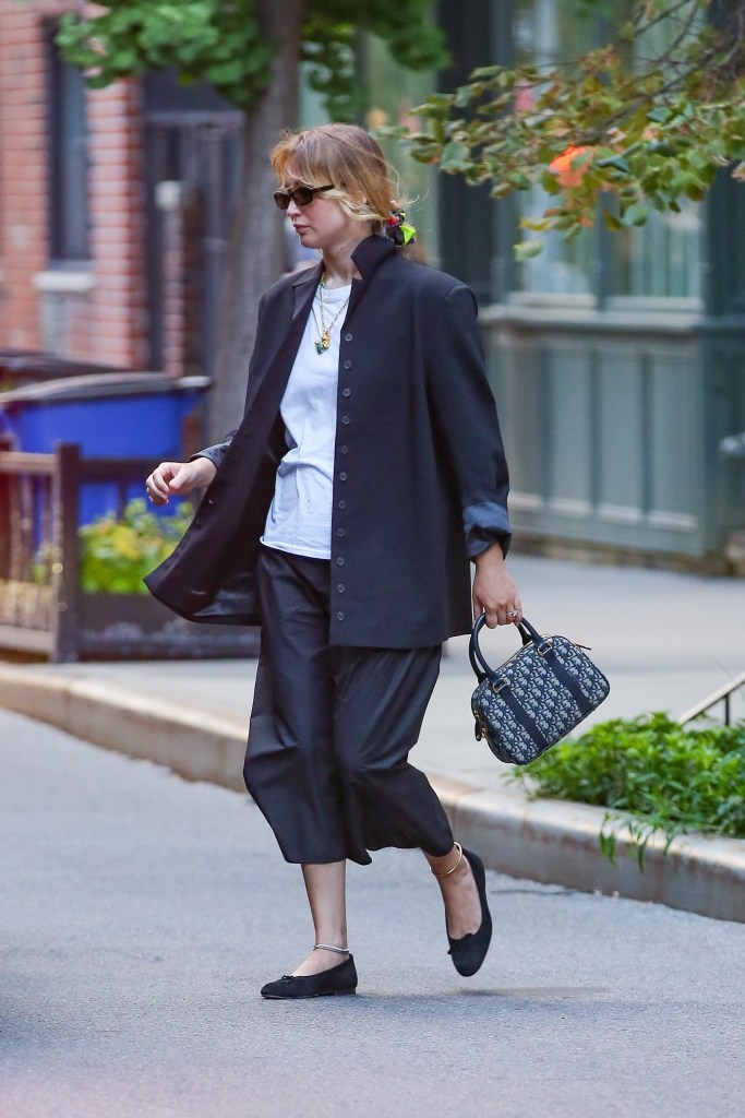 Jennifer Lawrence looks stunning in black and white ensemble while sporting a matching with a Dior bag in New York.