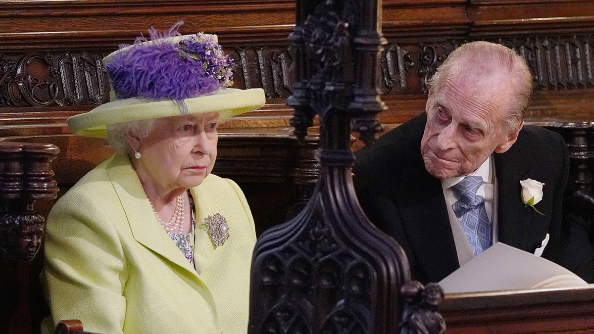 Prince Philip looking at a stern Queen Elizabeth inside St. George's Chapel during the wedding ceremony of the Duke and Duchess of Sussex.