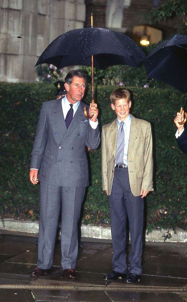 Charles holds an umbrella over his youngest son Harry's head on his first day at Eton Collage, September 1998