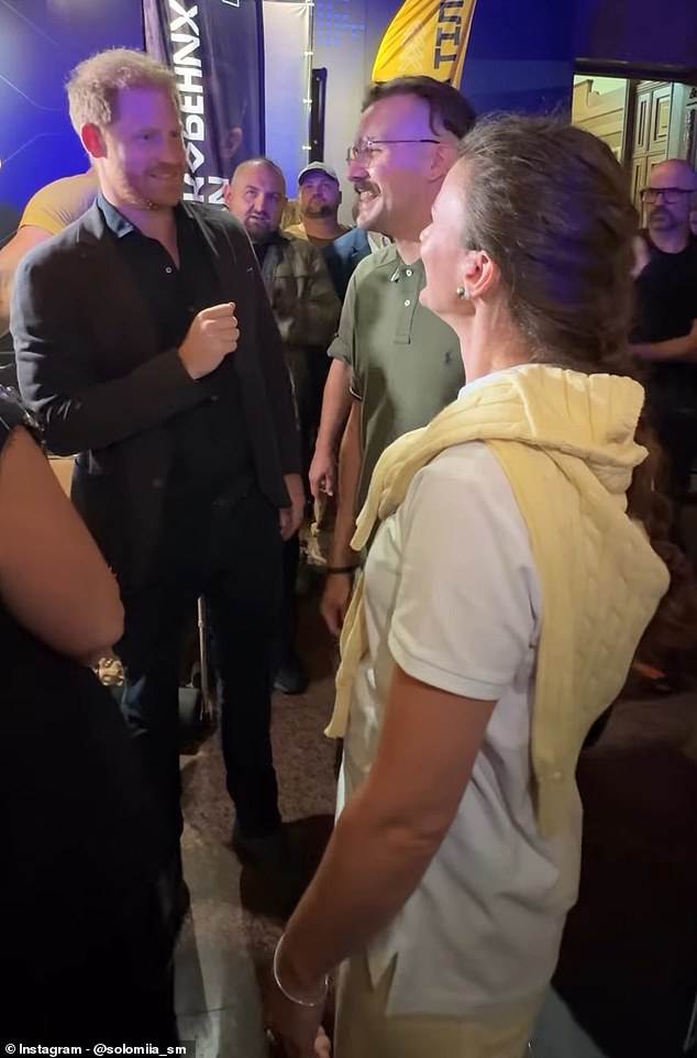 Prince Harry (pictured, left) was filmed while meeting a Ukrainian couple (pictured) at an event in the country