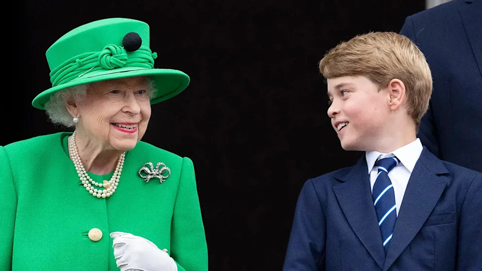 Prince George in a blue suit smiling at Queen Elizabeth