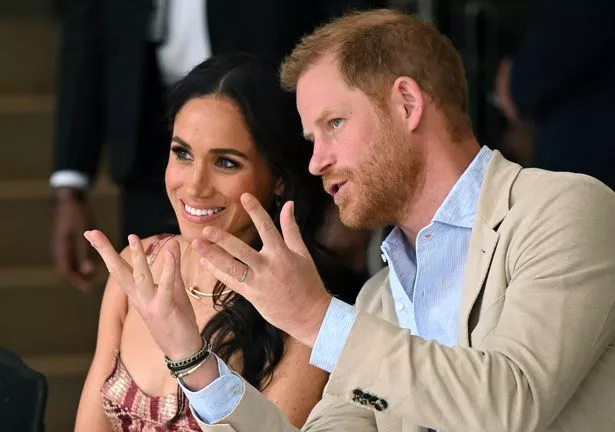 Duke of Sussex, speaks with his wife Meghan Markle while attending a show during a visit to the National Centre for the Arts in Bogota 