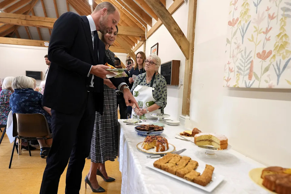 Prince William and Princess Kate selecting desserts from a long table