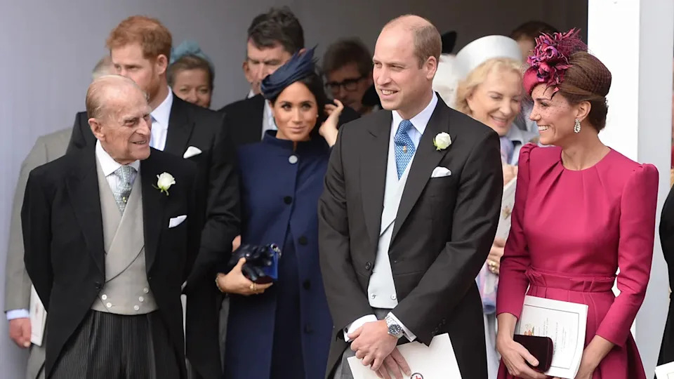 Kate Middleton smiling at Prince Philip as the other royals walk on.