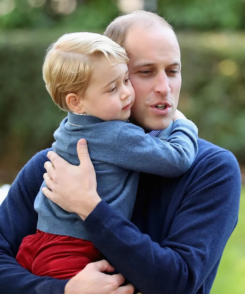 Prince William cuddling a young Prince George during a royal engagement.