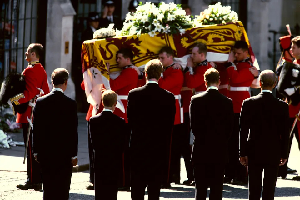 Prince Charles, Prince Harry, Prince William, Prince Philip and Prince Charles facing men carrying Princess Diana's coffin