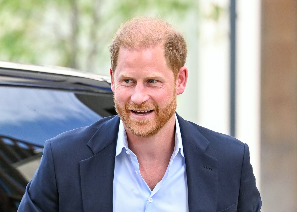 Prince Harry smiling in a suit outside