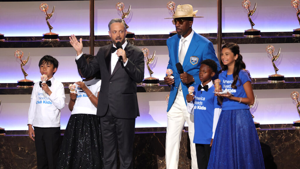 Emmys 2025 Raise $350K for Boys and Girls Club From Nate Bargatze Bit (Center L-R) Host Nate Bargatze and J. B. Smoove speak onstage during the 77th Primetime Emmy Awards at Peacock Theater on September 14, 2025 in Los Angeles, California.