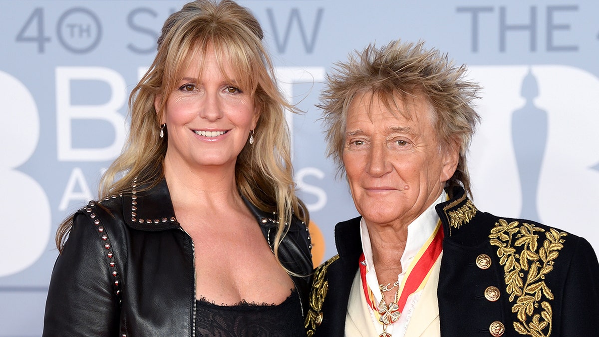 Penny Lancaster smiles next to husband Rod Stewart
