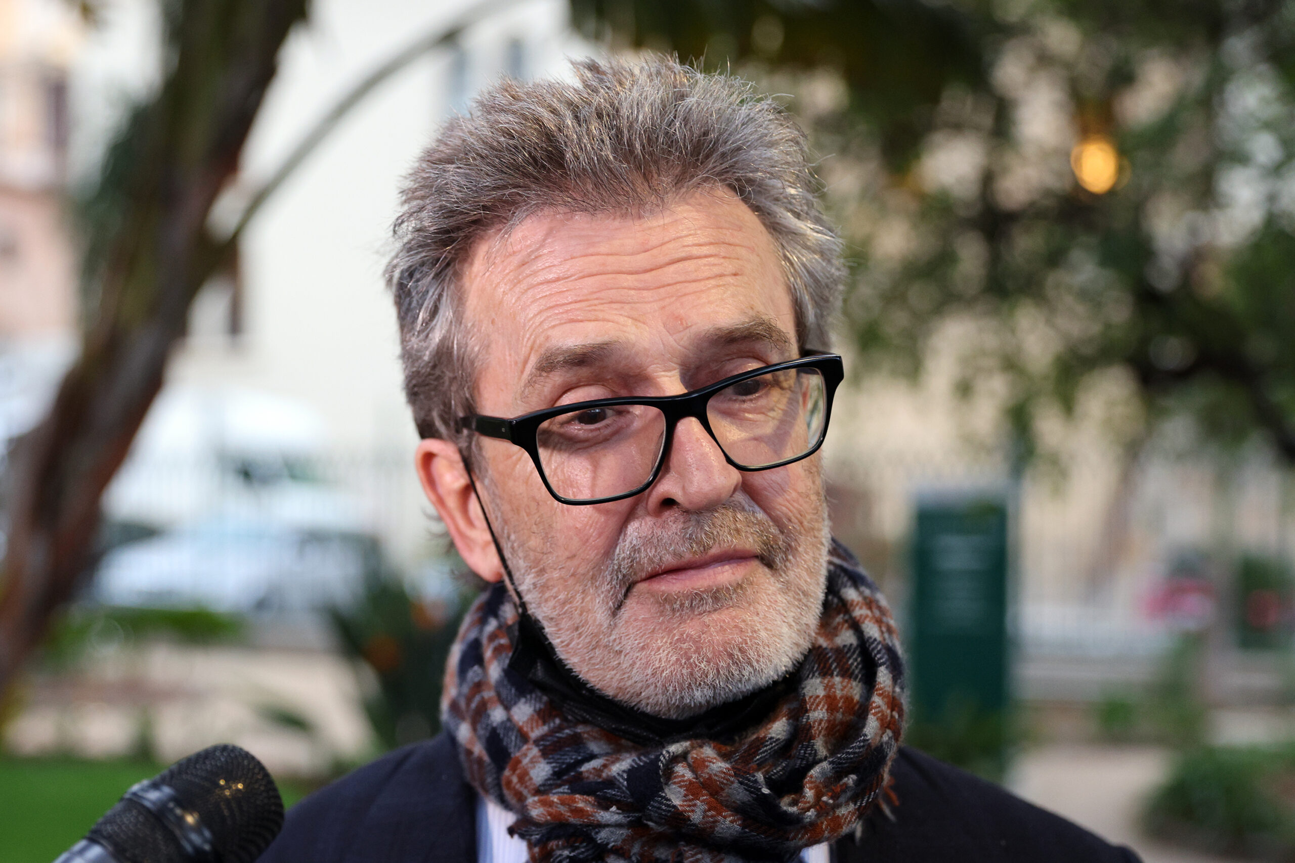 Rupert Everett wearing a scarf and glasses