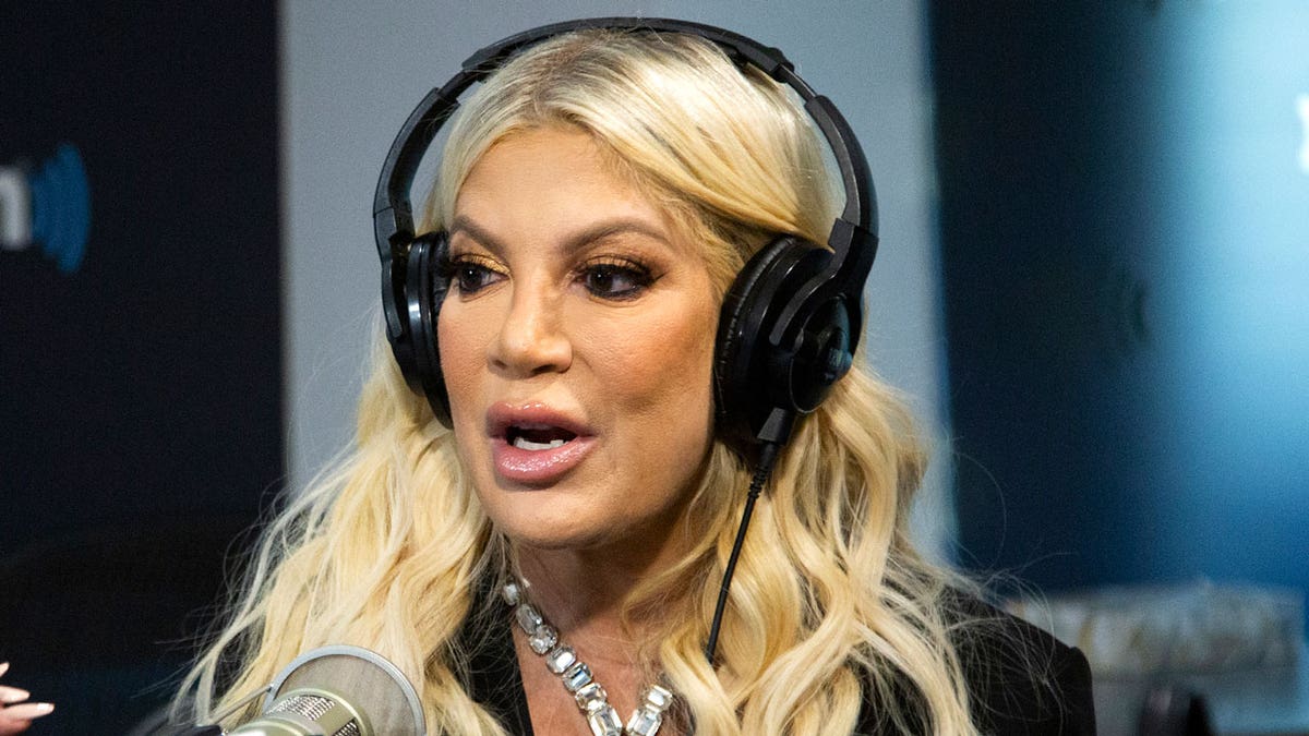 Tori Spelling talks into a microphone