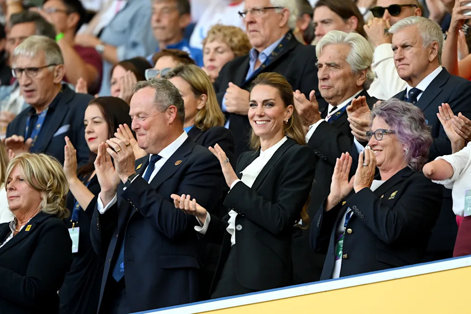Kate Middleton attends the women's rugby wearing a black suit and ruffled white shirt