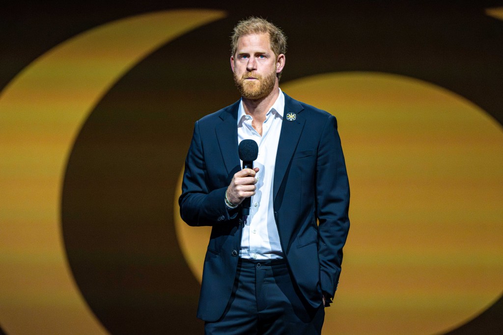 Prince Harry on stage holding a microphone