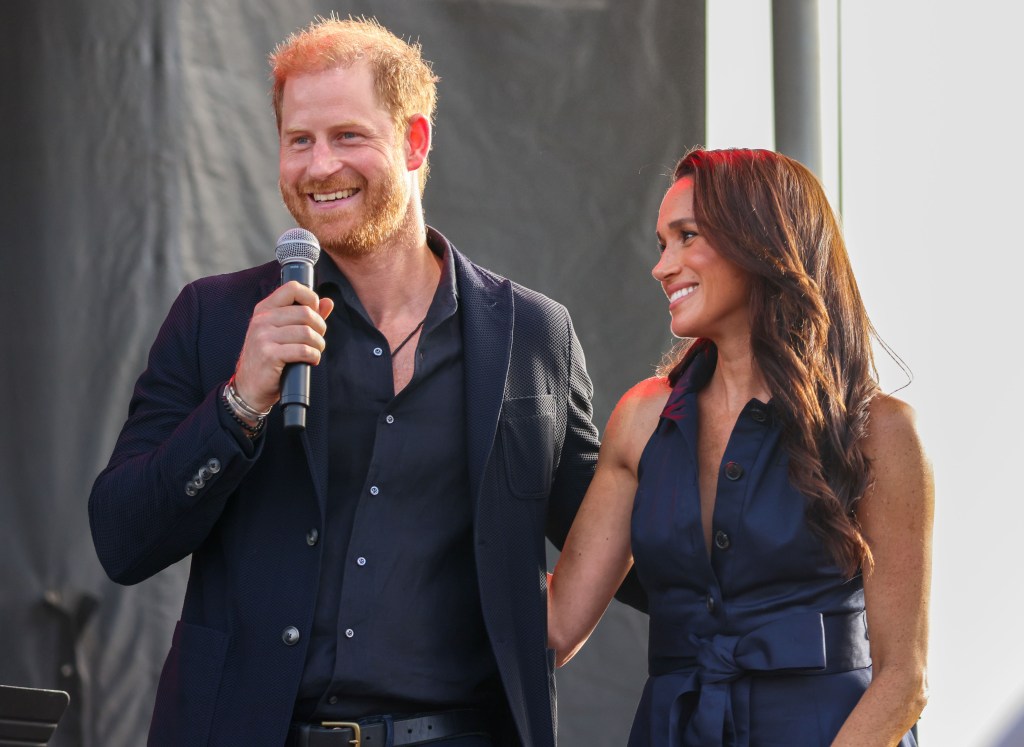 Prince Harry and Meghan Markle smiling at charity event