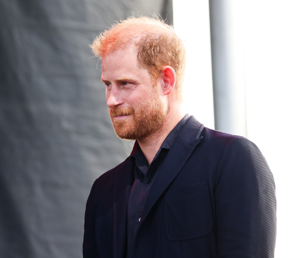 Prince Harry wears a black shirt and blazer