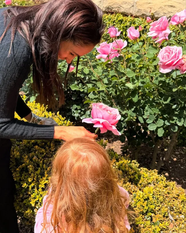 meghan and lilibet pick roses in the garden
