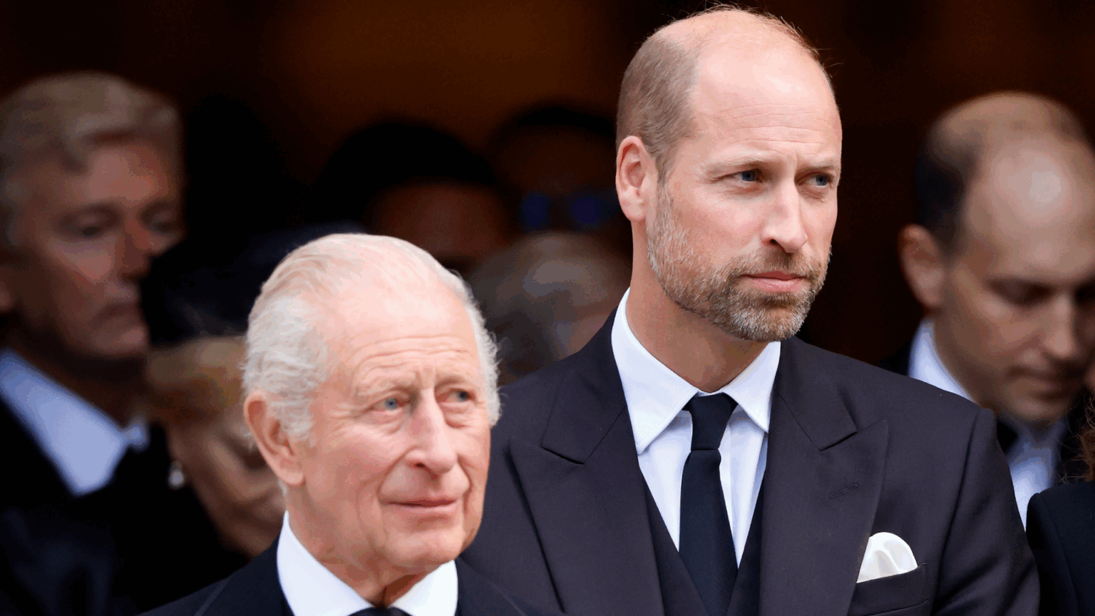 Prince William and King Charles wearing suits and ties standing next to each other