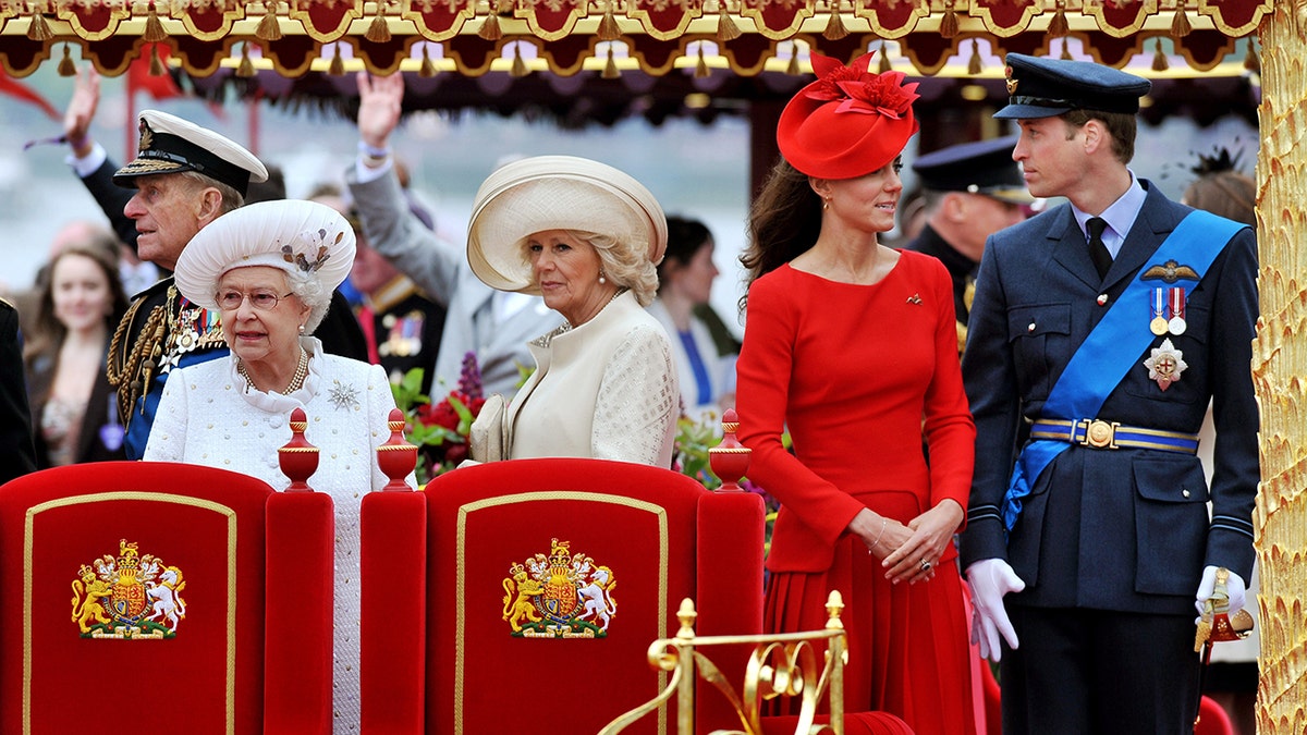 Kate Middleton standing next to her husband Prince William as the rest of the royal family looks on.