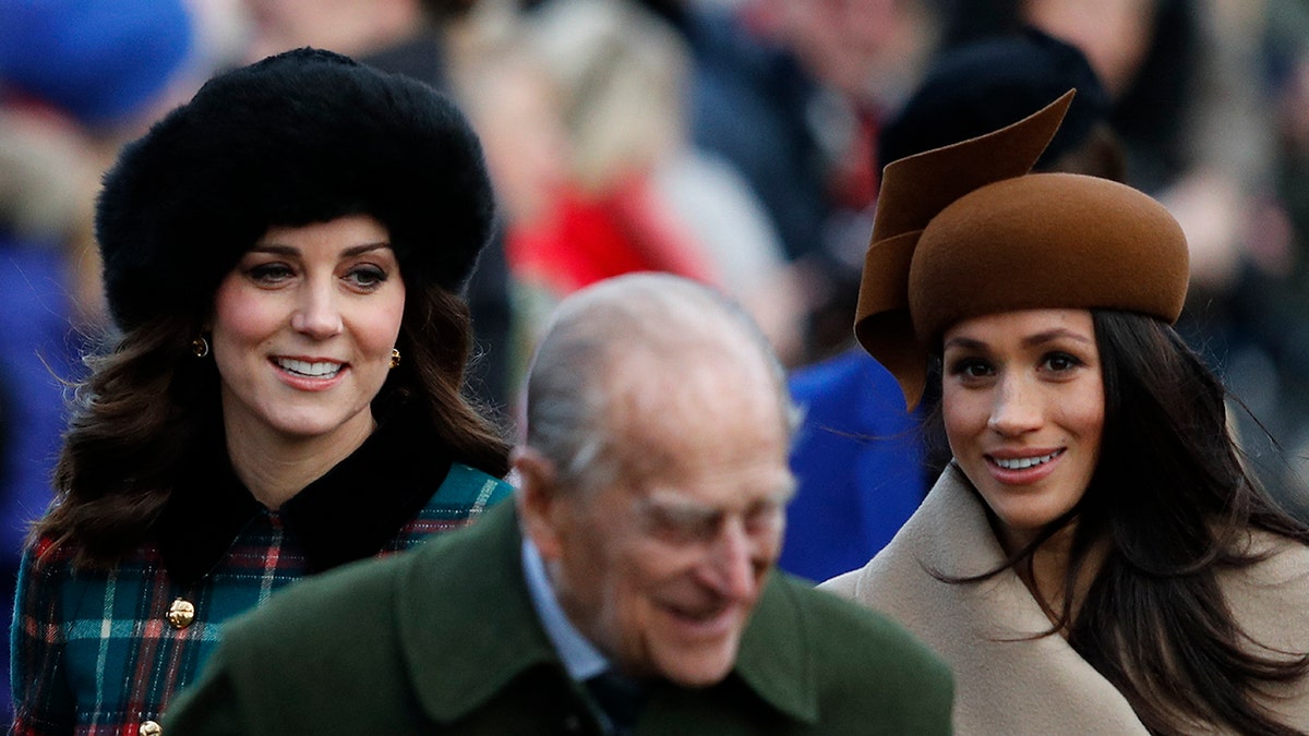Kate Middleton and Meghan Markle walking behind Prince Philip.