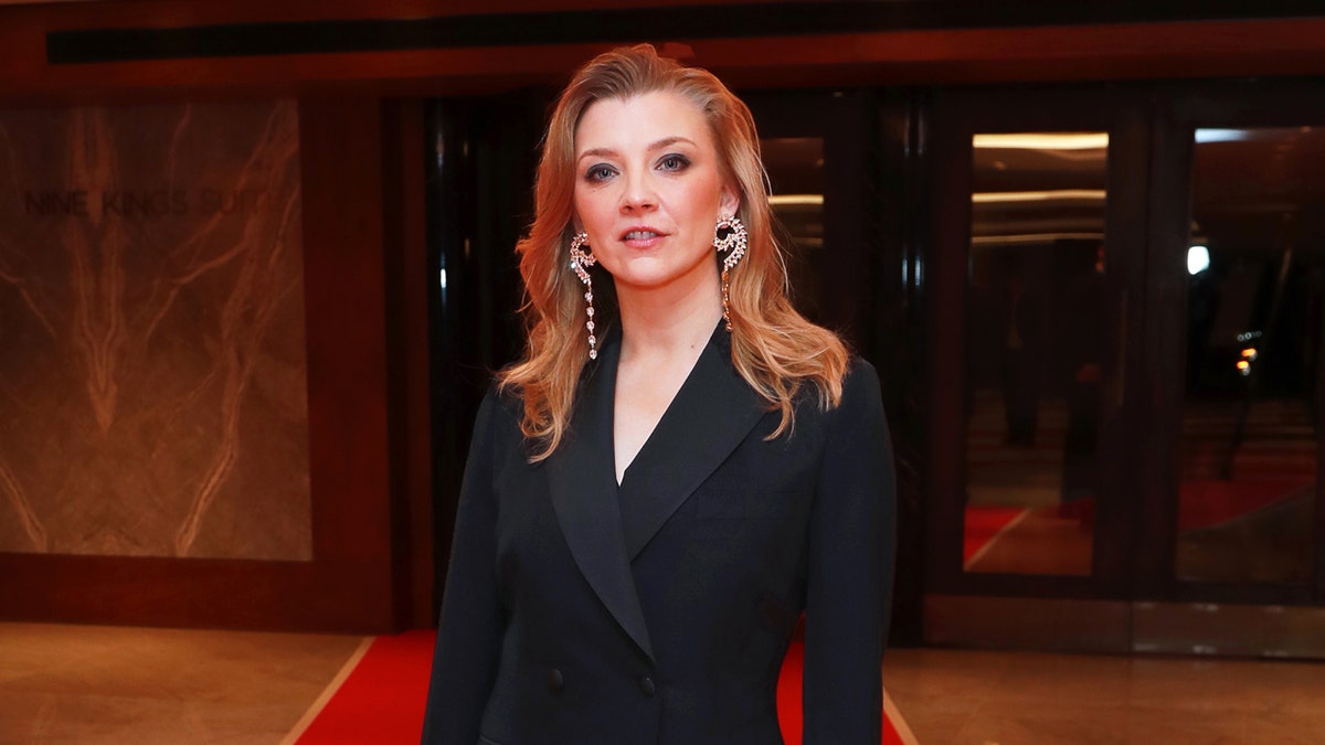A close-up of Natalie Dormer wearing a black suit.