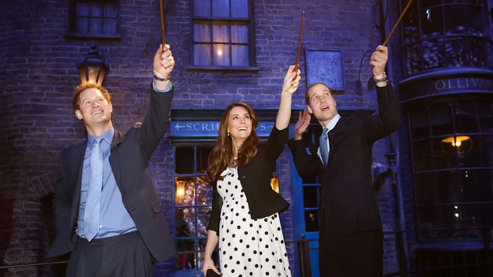 Prince Harry, Kate Middleton and Prince William waving wands at the opening of the Harry Potter studios tour, 2013