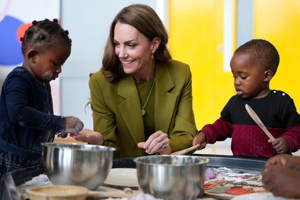 Kate joins in with messy play with some of the youngsters during her visit today 