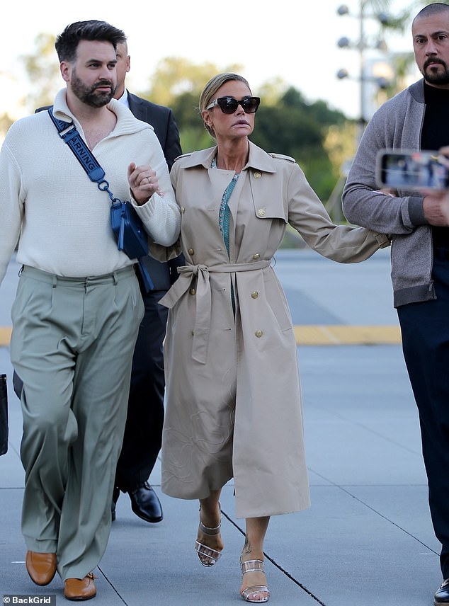 Denise Richards held on to two men as she exited court in Los Angeles on Wednesday. Denise took hold of the people around her, locking arms with a friend and a bodyguard following the day's legal proceedings