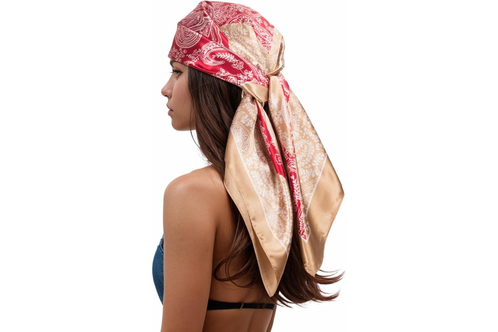 Red and gold paisley patterned satin headscarf tied on a woman's head.