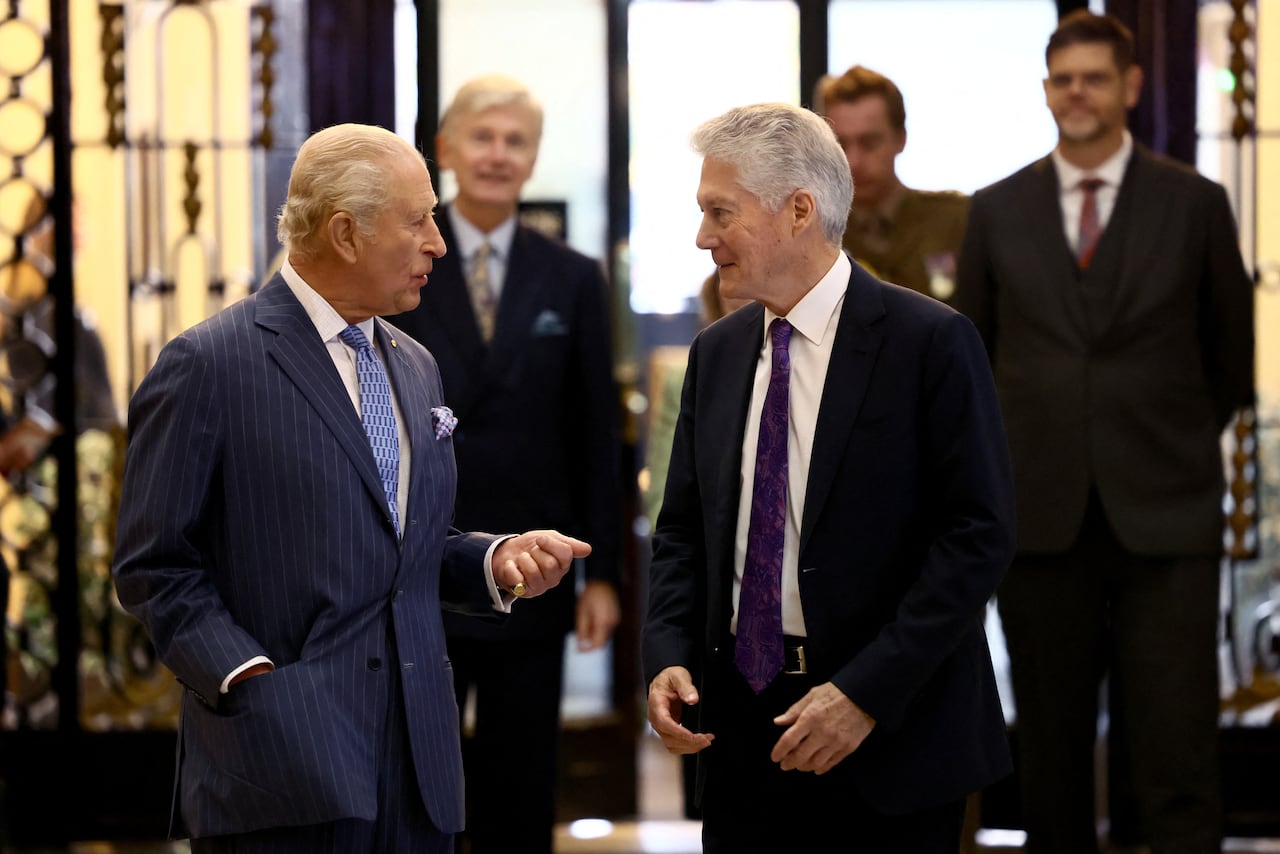 Two people stand talking to one another.