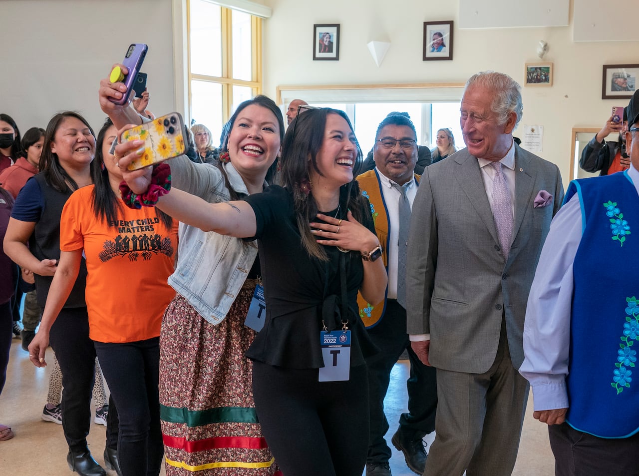 Several people stand in a line while one takes a selfie.
