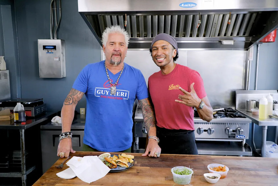 Guy Fieri posing with Chef/Owner Leon Charles Brunson in the kitchen of Leon's At Lake Ella in Tallahassee, Florida as seen in Food Network's Diners Drive-Ins and Dives.