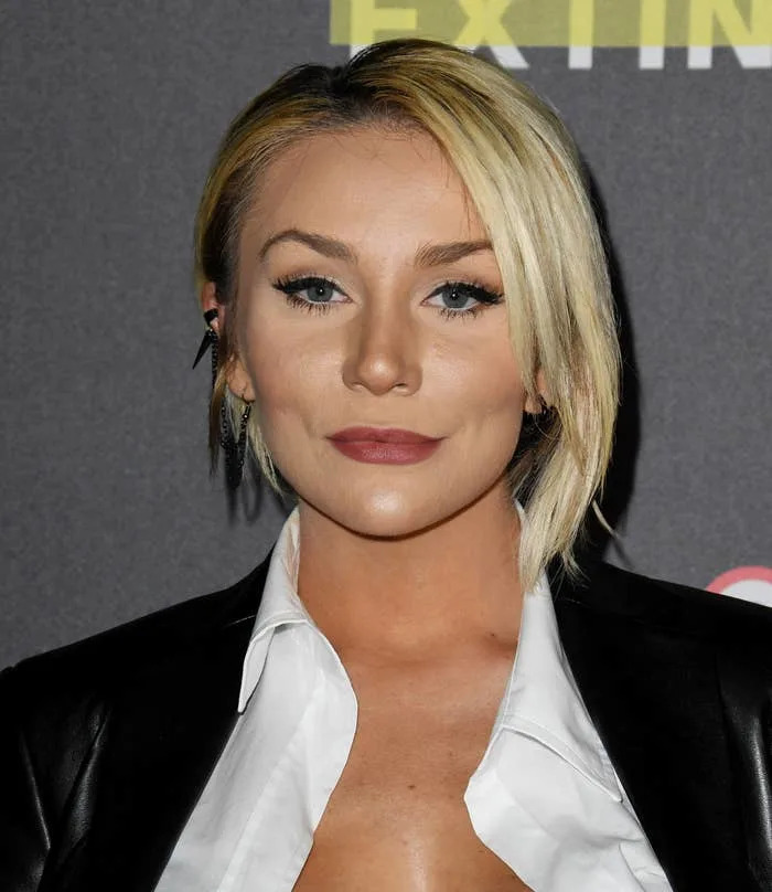 Courtney Stodden with short blond hair wearing a shirt under leather jacket, posing at a public event