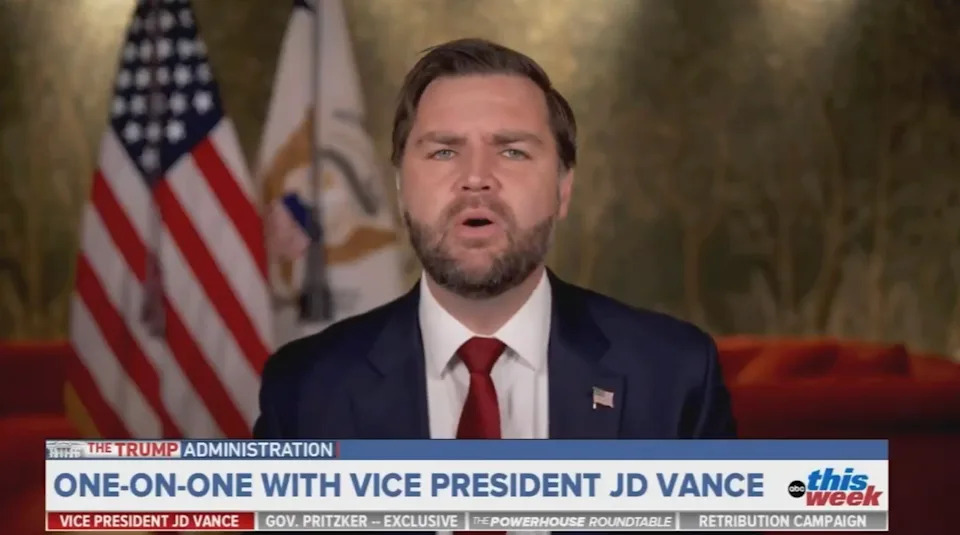 A man in a suit is speaking on a news program. The screen reads, "One-on-one with Vice President JD Vance." U.S. flags are in the background