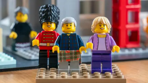 PA Media Lego minifigures of King Charles III and Queen Camilla, with a Scots Guard, outside a scale Lego model of the Albert Hall in Ballater, which were built by Nicola Reid from Ballater Lego Club to mark the royal visit.