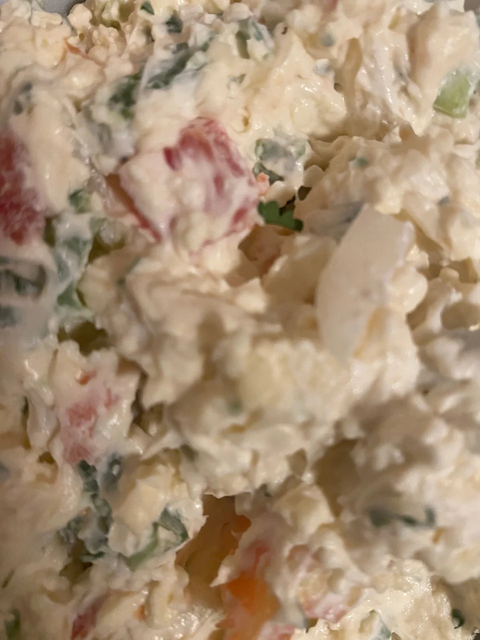 Close-up of a mixed salad with visible chopped vegetables and creamy dressing