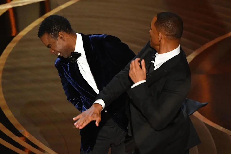 ROBYN BECK/AFP via Getty Images Will Smith and Chris Rock onstage at the 2022 Oscars