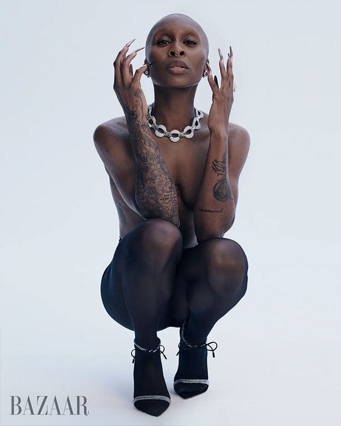 Cynthia Erivo posing in sheer black tights and heels with tattoos and jewelry in controversial Harper’s Bazaar shoot.