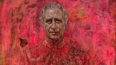 Jonathan Yeo Studio The top third of artist Jonathan Yeo's portrait of King Charles. Charles wears a ceremonial military uniform and a butterfly hovers above his left shoulder, as we look at the painting. The King appears against a striking red background and stares out from the portrait. 