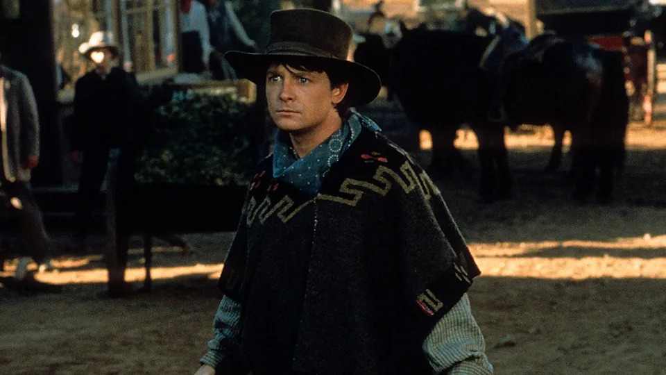 Michael J. Fox in a poncho and hat while filming "Back to the Future III" in 1990.