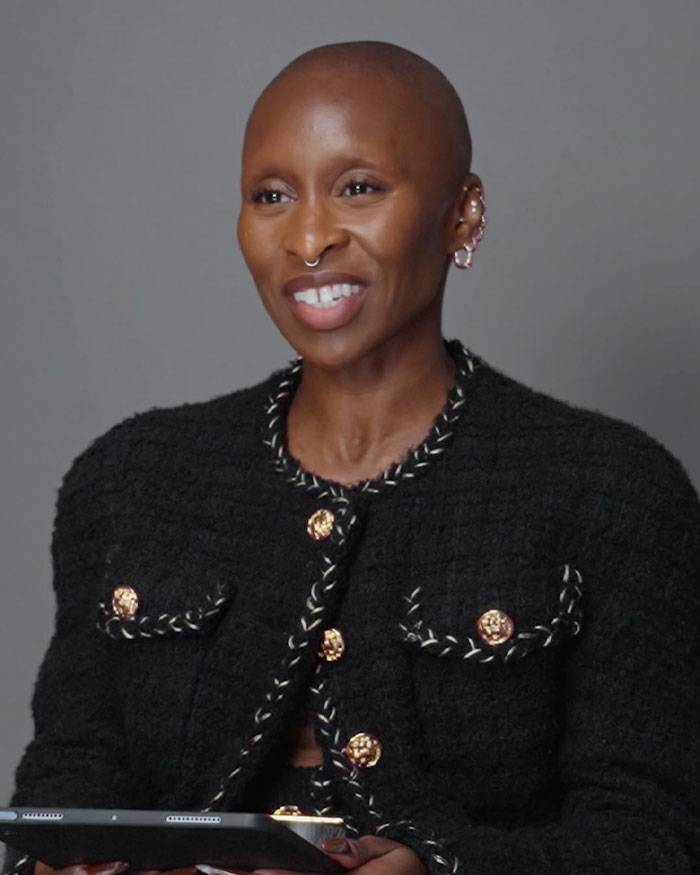 Cynthia Erivo wearing a black textured jacket and smiling during a discussion about the controversial Harper’s Bazaar shoot.