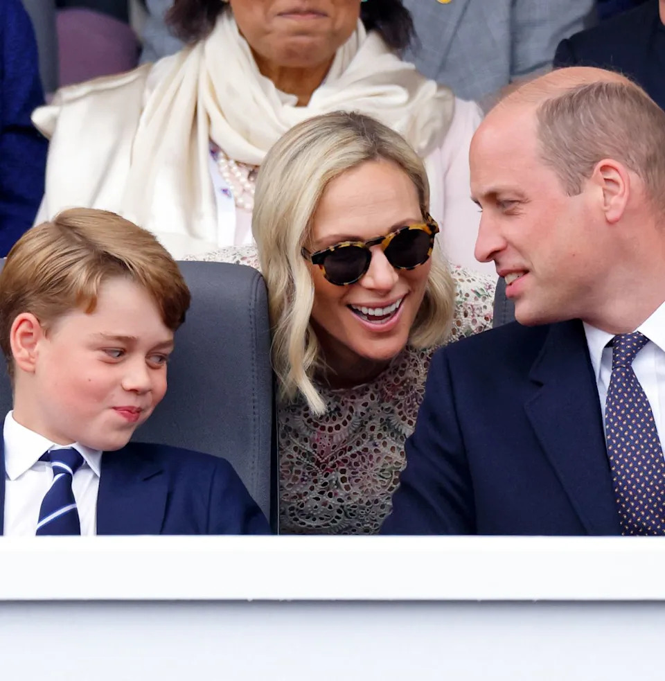  Prince George smirking as Zara Tindall leans over and talks to Prince William. 