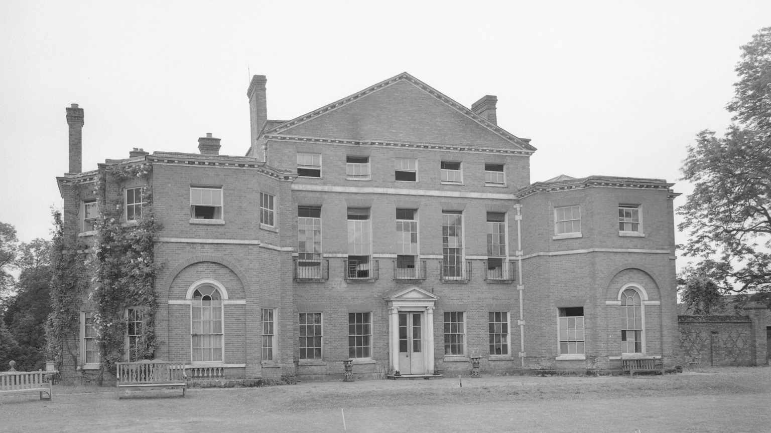 Royal Family Faces “Difficult and Rather Sensitive Decision” Over Royal Lodge’s Future After Prince Andrew Exit A black and white photo of the exterior of Royal Lodge Windsor