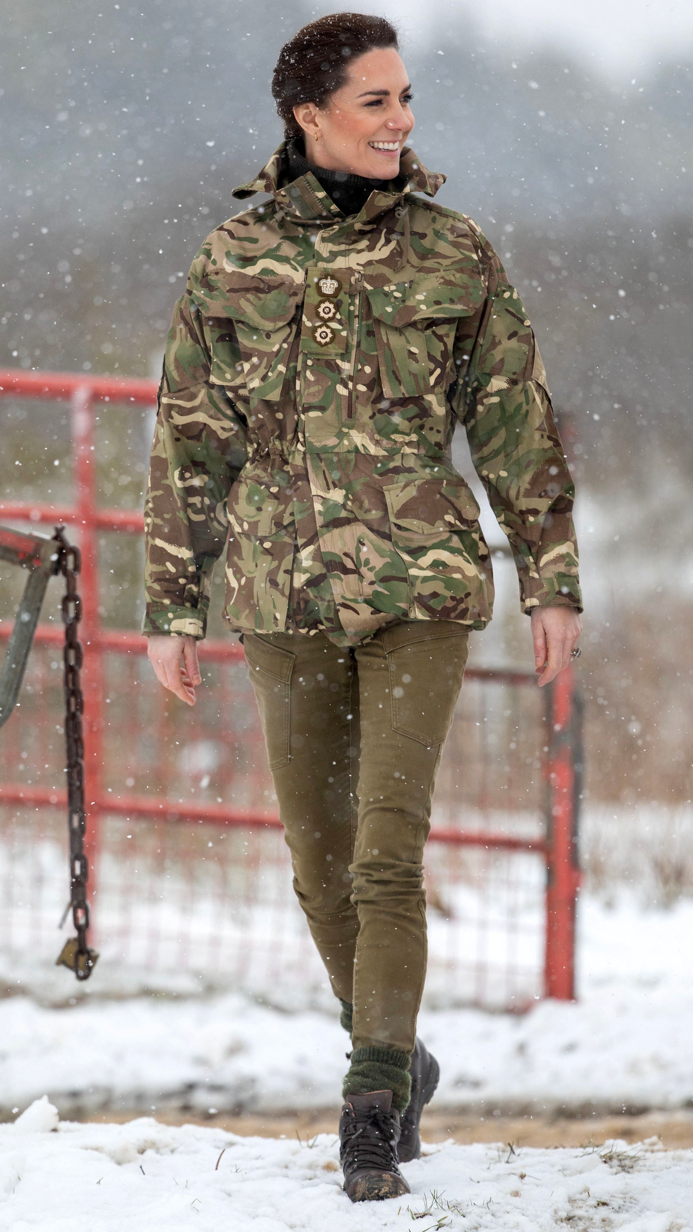 Catherine, Princess of Wales reacts as she walks in the snow while meeting members of the 1st Battalion Irish Guards during her visit to the Salisbury Plain Training Area