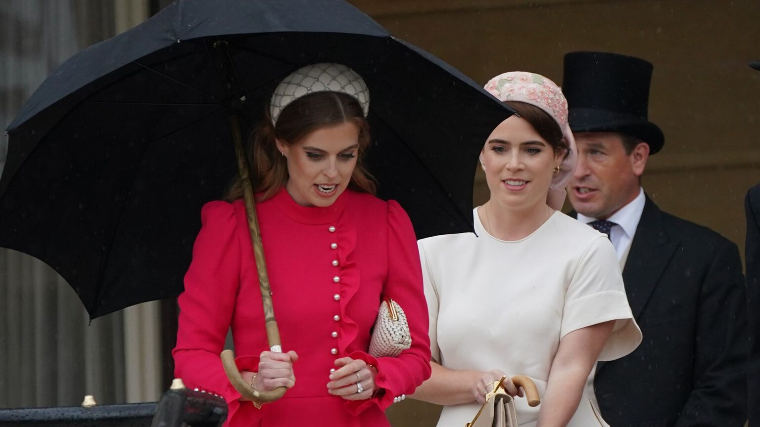 Why Princess Beatrice and Princess Eugenie Can Still “Hold Their Heads High” in Spite of Their Parents’ Scandal LONDON, ENGLAND - MAY 21: Princess Beatrice (C) and Princess Eugenie (in white) arrive for the Sovereign's Garden Party at Buckingham Palace on May 21, 2024 in London, England. (Photo by Yui Mok-WPA Pool/Getty Images)