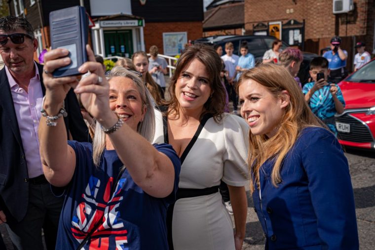 CHALFONT ST GILES, ENGLAND - MAY 07: Princess Beatrice of York (R) and Princess Eugenie of York pose for a selfie as they attend a Coronation Big Lunch in Chalfont St Giles, Buckinghamshire on May 7, 2023 in Chalfont St Giles, England. People around the UK are celebrating with street parties after Charles III and his wife, Camilla, were crowned as King and Queen of the United Kingdom of Great Britain and Northern Ireland, and the other Commonwealth realms. The Coronation took place yesterday at Westminster Abbey eight months after Charles acceded to the throne on 8 September 2022, on the death of his mother, Elizabeth II. (Photo by Ben Birchall - WPA Pool/Getty Images)