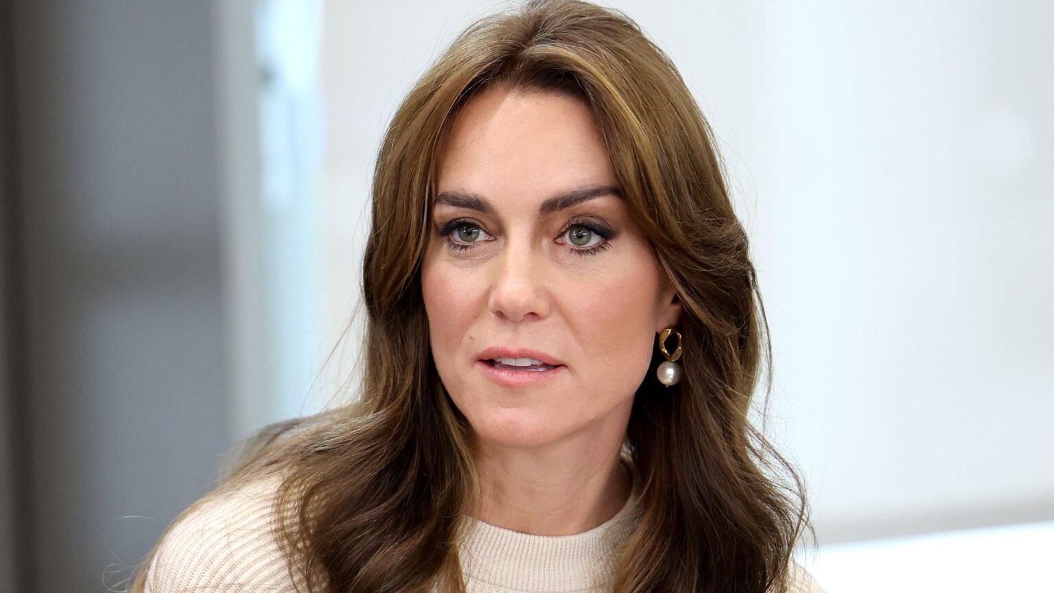 Actor Describes Kate Middleton as the Royal Family’s Savior Kate Middleton has long brown hair and wears a cream sweater
